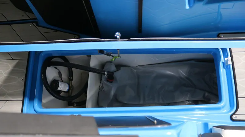 Slide: The Image of 2023 Yamaha Boats 222XD storage compartment with blue interior and visible hoses. - 19