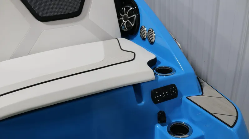 Slide: The Image of 2023 Yamaha Boats 222XD interior, featuring blue and white seating with cup holders and speaker system. - 30