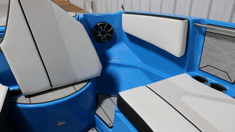 Slide: The Image of Interior seating of 2023 Yamaha Boats 222XD, featuring blue and white upholstery with cup holders. - 7