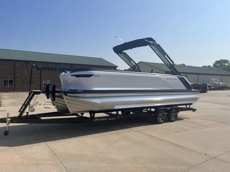 Slide: The Image of 2023 Manitou Explore 24 Switchback pontoon boat on trailer, parked outdoors. - 5