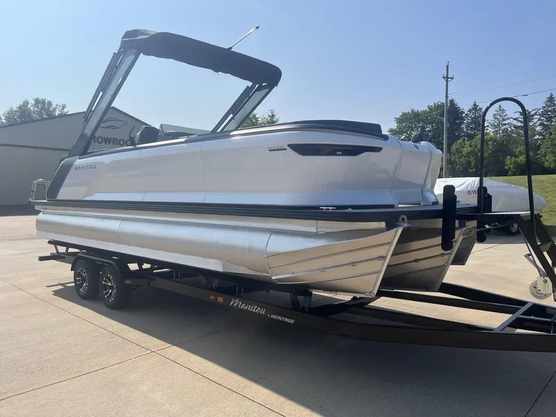 Slide: The Image of 2023 Manitou Explore 24 Switchback pontoon boat on trailer, outdoor setting. - 6