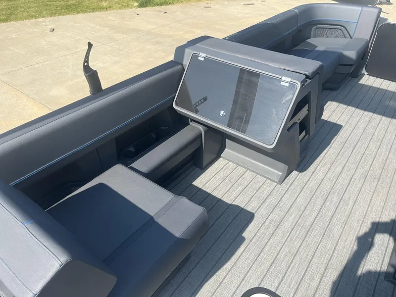 Slide: The Image of 2023 Manitou Explore 24 Switchback boat interior with gray seating and deck. - 9