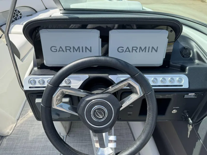 Slide: The Image of 2024 Crownline 240SS boat dashboard with dual Garmin displays and steering wheel. - 15