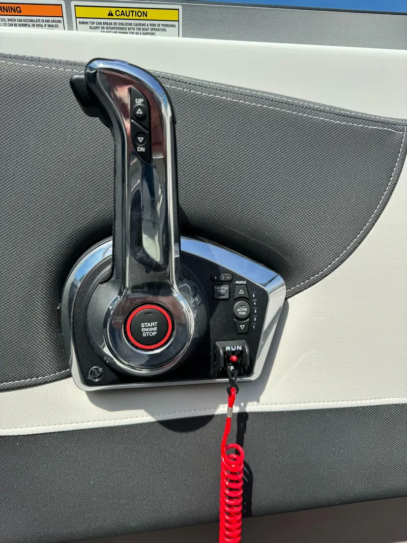 Slide: The Image of 2024 Crownline 240SS boat throttle control with start/stop button and safety lanyard. - 24