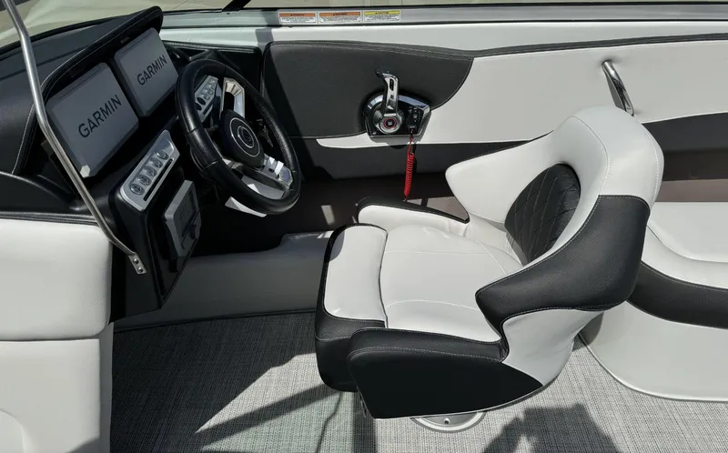 Slide: The Image of 2024 Crownline 240SS boat cockpit with Garmin displays and black-and-white seating. - 25