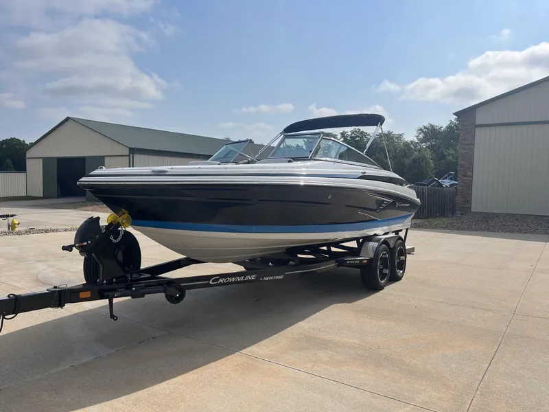 Slide: The Image of 2024 Crownline 240SS boat on trailer in sunny driveway. - 3