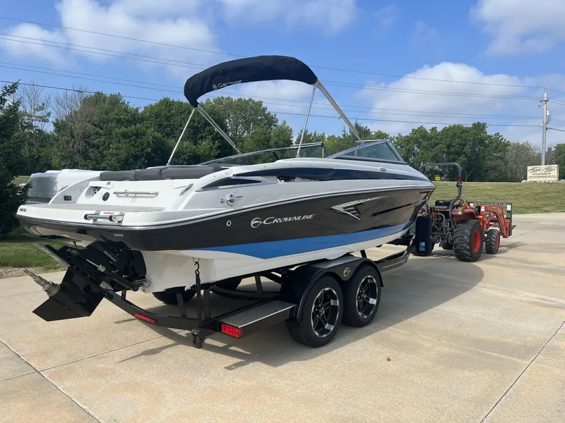 Slide: The Image of 2024 Crownline 240SS boat on trailer, parked outdoors under a clear sky. - 5