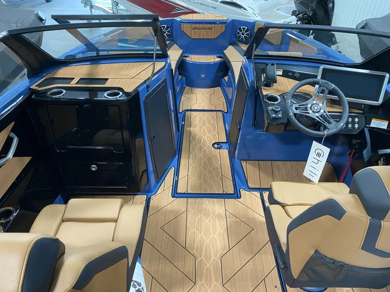 Slide: The Image of 2024 Yamaha Boats 222XE interior with modern dashboard, tan seats, and wood-style flooring. - 3