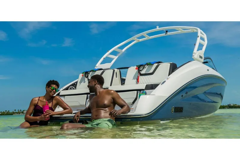 Slide: The Image of 2024 Yamaha Boats 252S in shallow water with two people relaxing. - 18