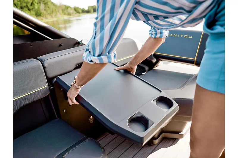 Slide: The Image of Person adjusting table on 2024 Manitou Explore 24 Navigator boat interior. - 19