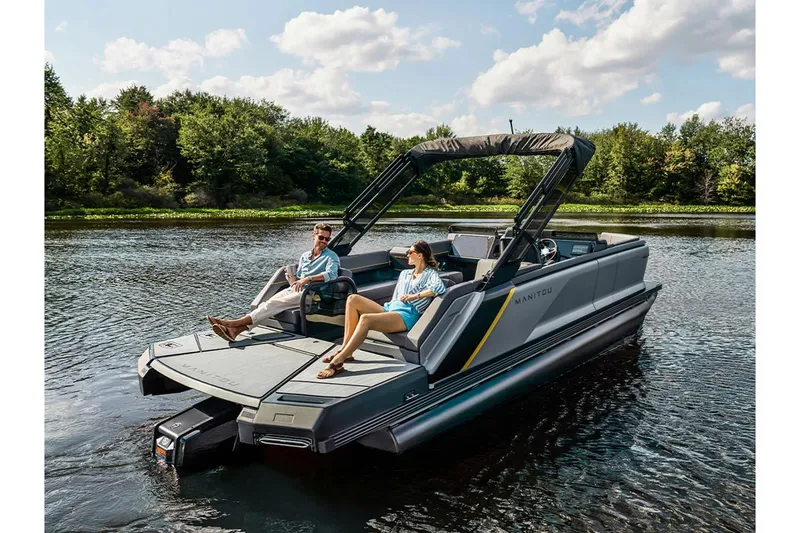 Slide: The Image of 2024 Manitou Explore 24 Navigator pontoon boat on a serene lake. - 26