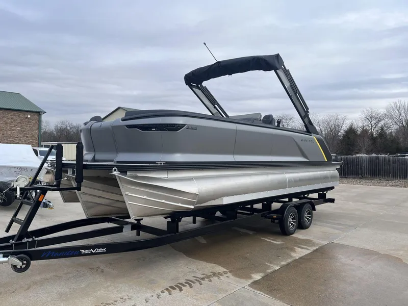 Slide: The Image of 2024 Manitou Explore 24 Navigator pontoon boat on trailer, parked outdoors. - 3