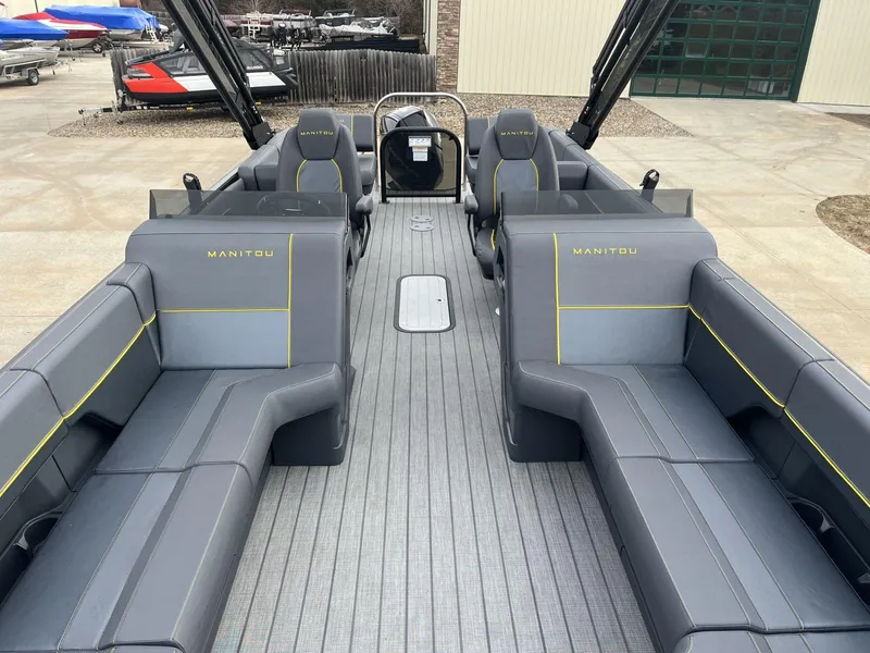 Slide: The Image of 2024 Manitou Explore 24 Navigator boat interior with gray seating and yellow accents. - 5