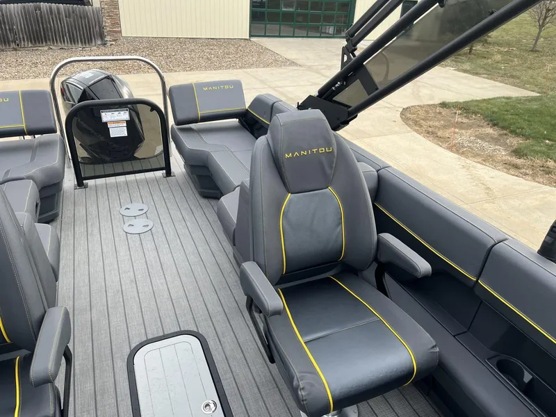 Slide: The Image of 2024 Manitou Explore 24 Navigator boat interior with gray seating and yellow accents. - 6