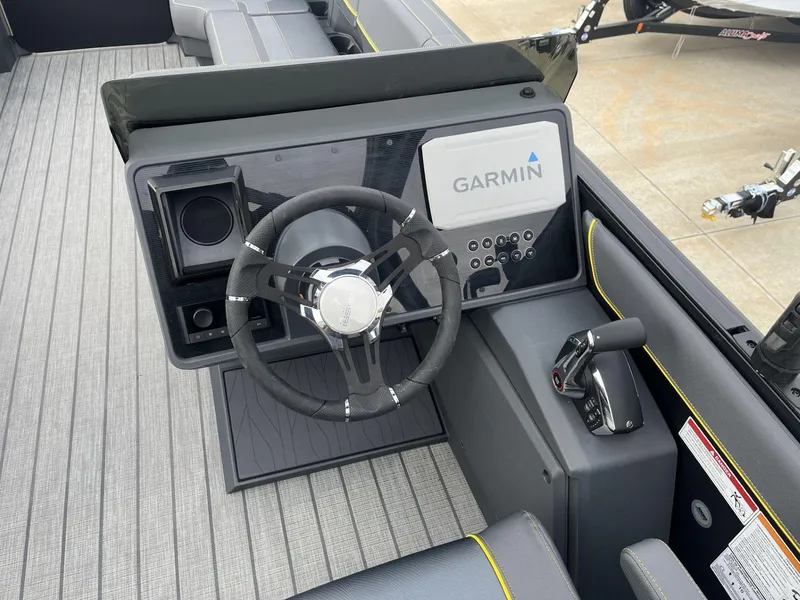 Slide: The Image of 2024 Manitou Explore 24 Navigator dashboard with Garmin navigation system and steering wheel. - 8