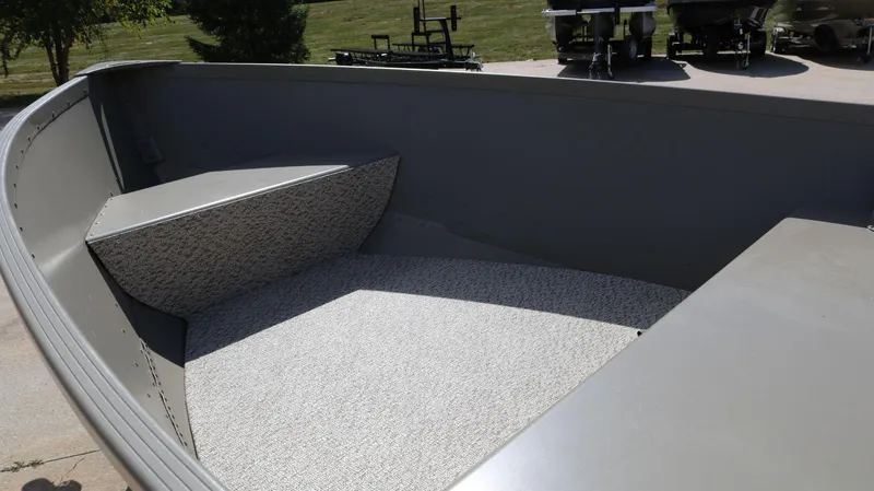 Slide: The Image of 2024 Alumacraft V-16 Tiller boat interior with carpeted seating and storage area. - 12