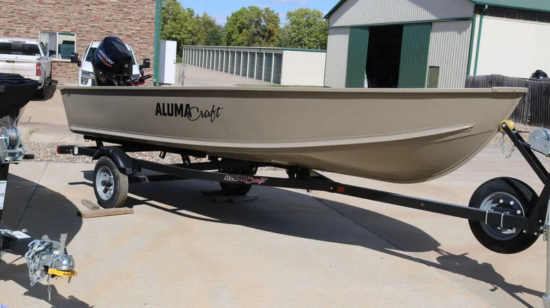 Slide: The Image of 2024 Alumacraft V-16 Tiller boat on trailer, parked outdoors. - 7