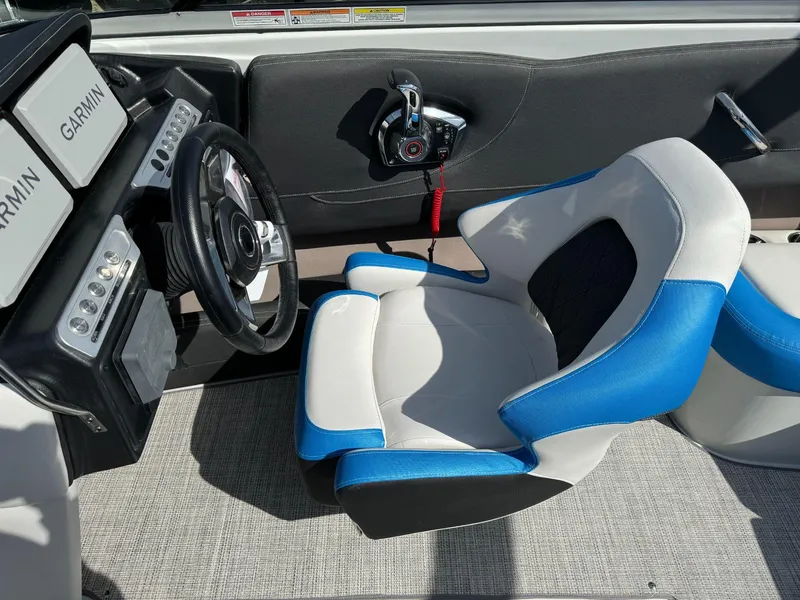 Slide: The Image of 2024 Crownline 220SS boat cockpit with Garmin displays and blue-accented captain's chair. - 10