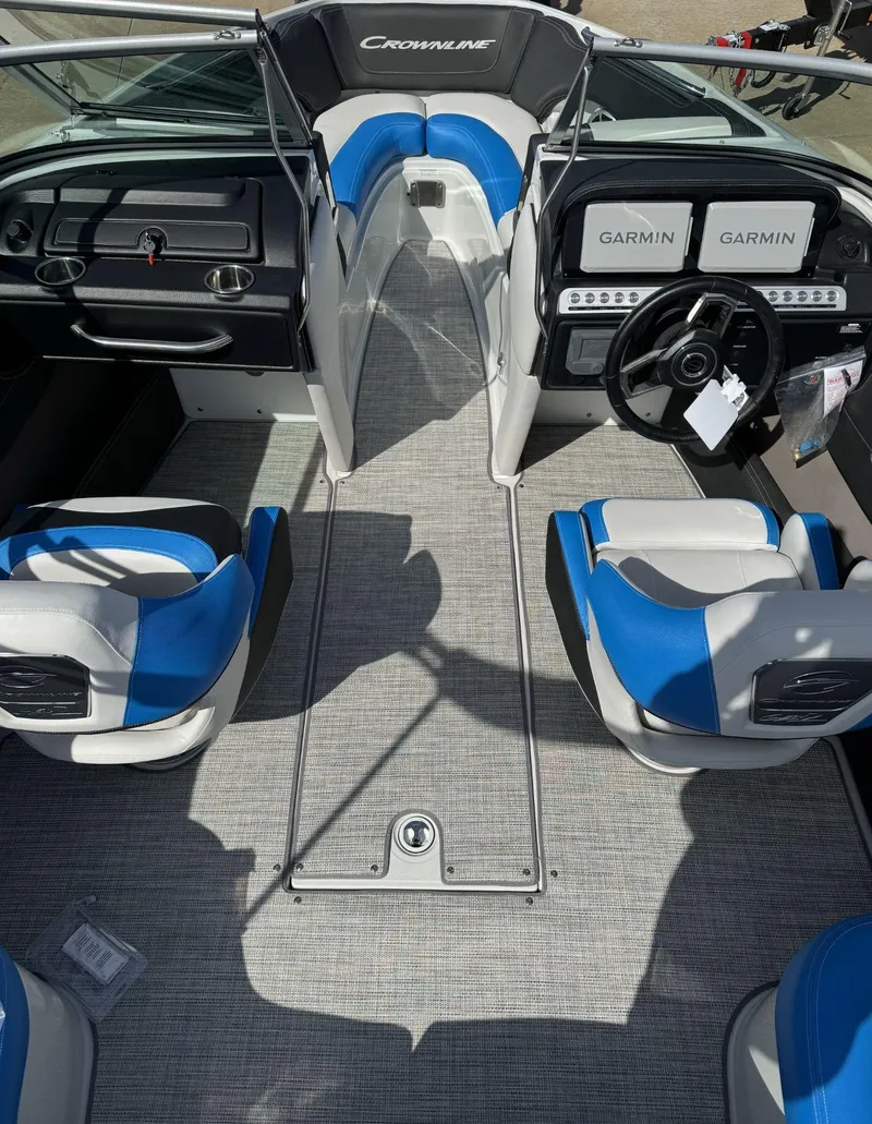Slide: The Image of 2024 Crownline 220SS boat interior with blue and white seating, Garmin displays, and steering wheel. - 5