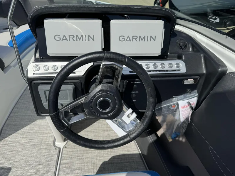 Slide: The Image of 2024 Crownline 220SS boat dashboard with Garmin navigation displays and steering wheel. - 8
