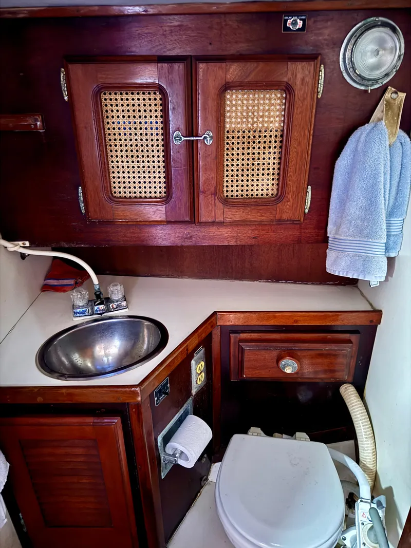 Slide: The Image of 1979 Islander IP Peterson 40 yacht bathroom with wooden cabinets and stainless steel sink. - 12