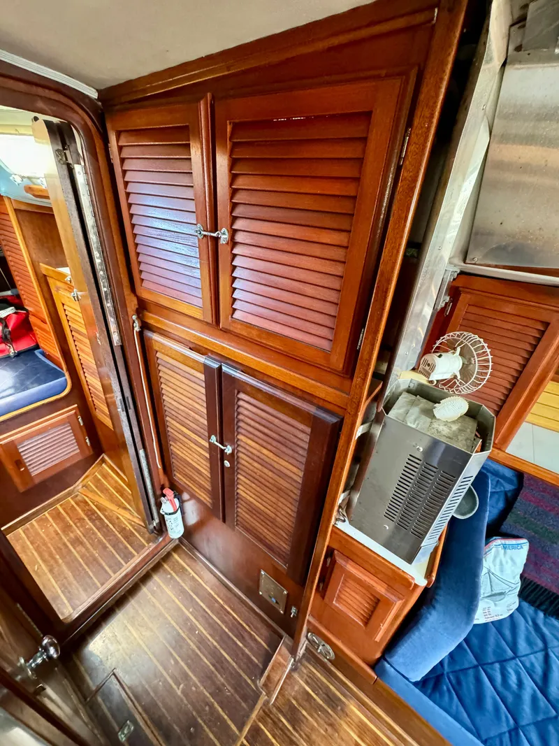 Slide: The Image of 1979 Islander IP Peterson 40 interior with wooden cabinets and seating area. - 13