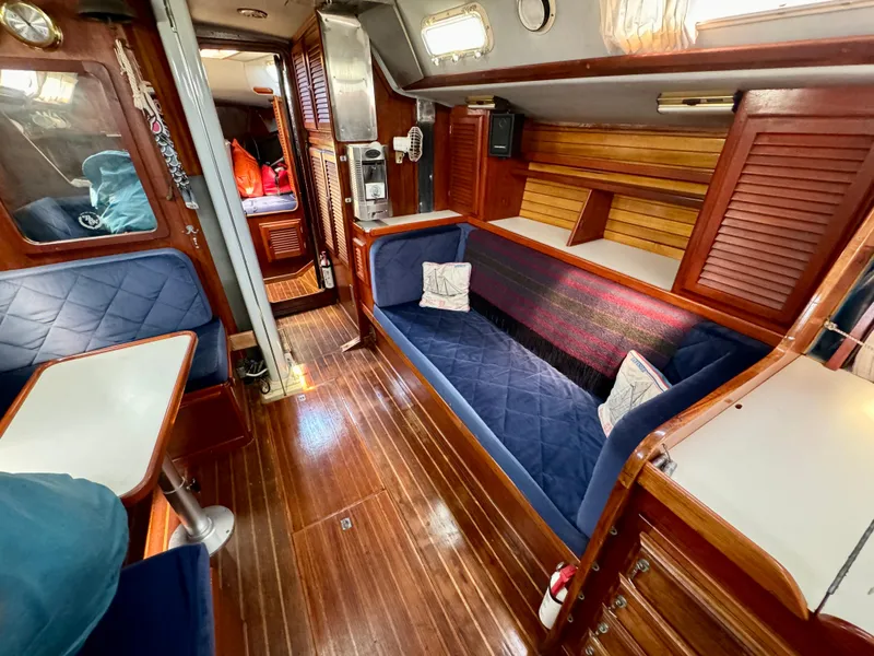 Slide: The Image of Interior of 1979 Islander IP Peterson 40 sailboat with wooden finishes and blue seating. - 22