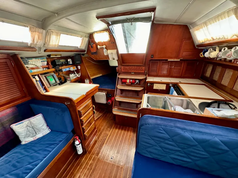 Slide: The Image of Interior of 1979 Islander IP Peterson 40 sailboat with wood finish and blue seating. - 23