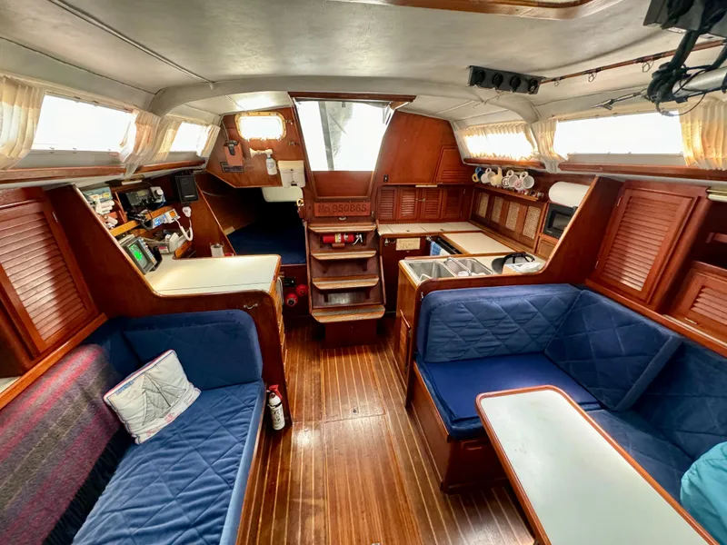Slide: The Image of Interior of 1979 Islander IP Peterson 40 sailboat with wooden furnishings and blue seating. - 26