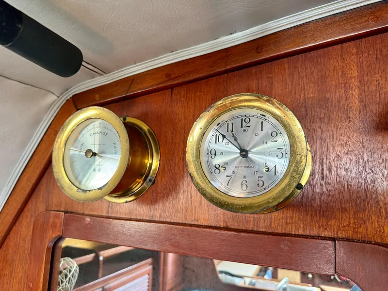Slide: The Image of Brass clock and barometer on 1979 Islander IP Peterson 40 yacht's wooden interior. - 31