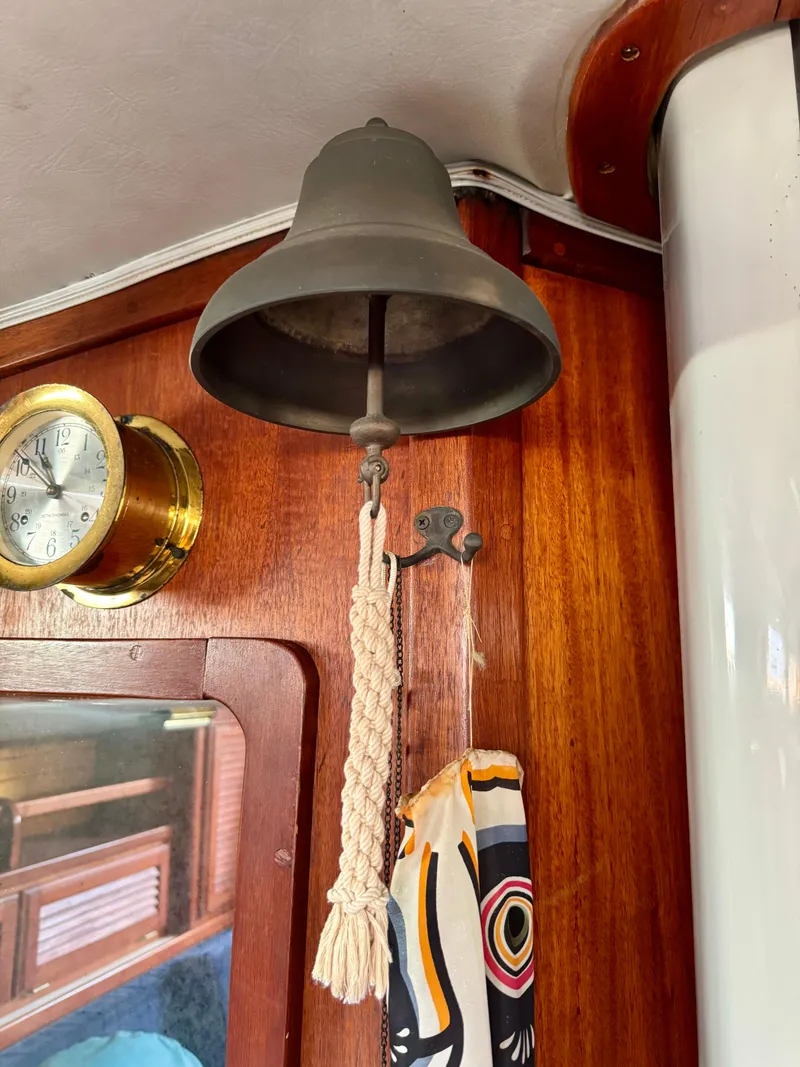 Slide: The Image of Vintage ship bell on 1979 Islander IP Peterson 40, with nautical decor and clock. - 32