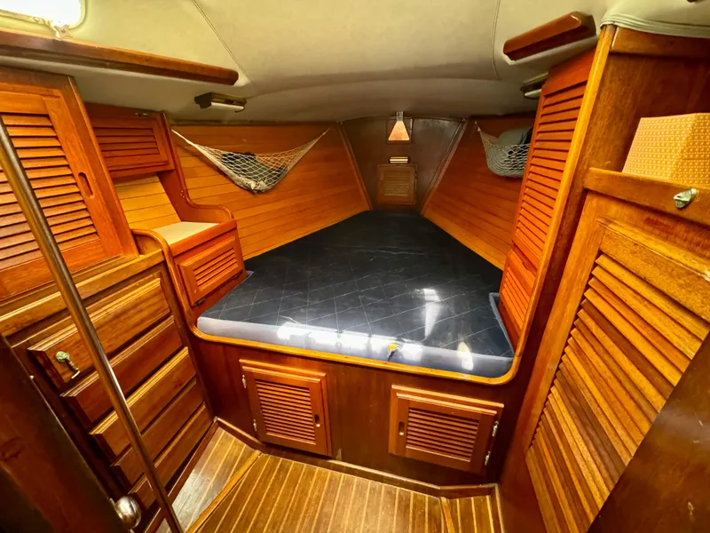 Slide: The Image of 1979 Islander IP Peterson 40 cabin with wooden interior and cozy sleeping area. - 6