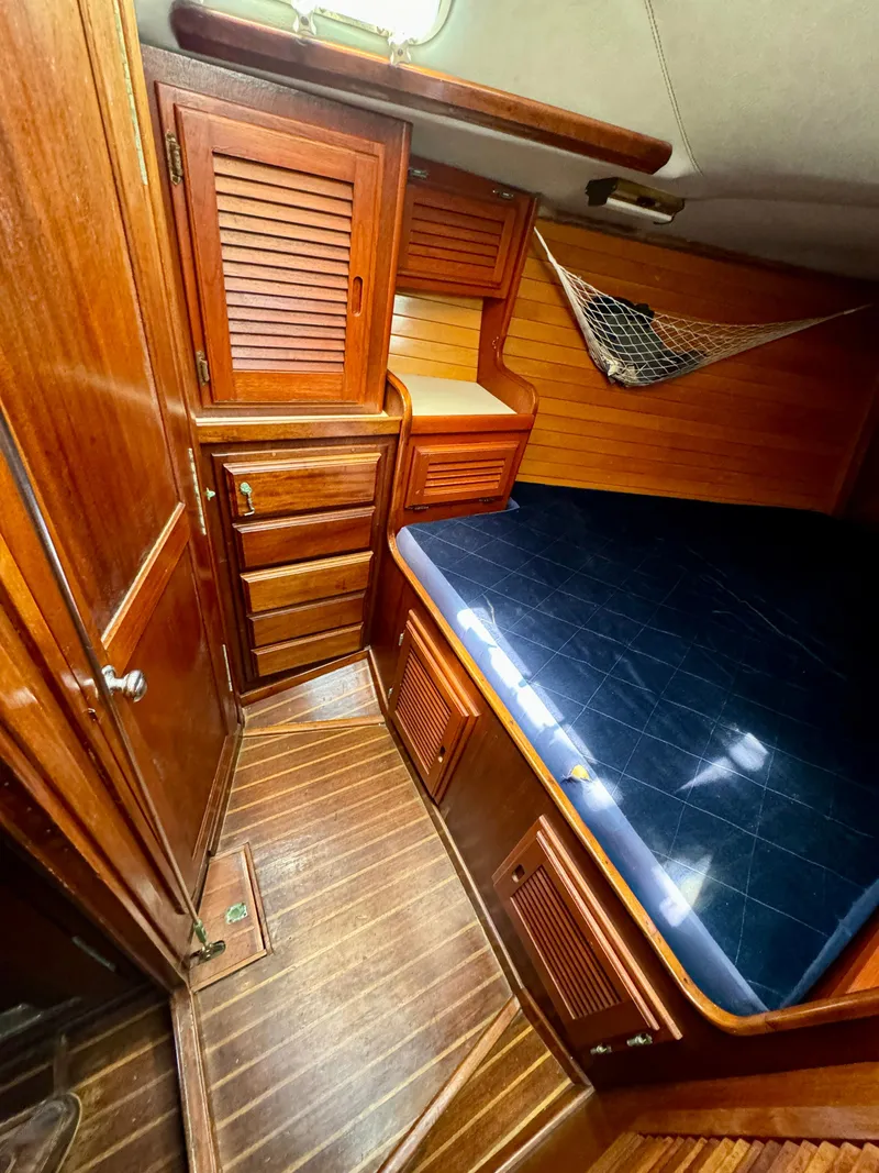 Slide: The Image of 1979 Islander IP Peterson 40 cabin with wooden interior and blue bedding. - 7