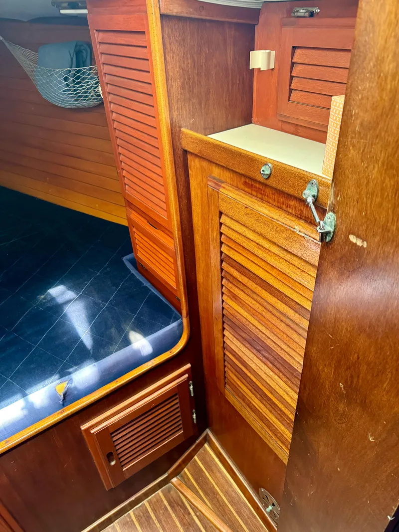 Slide: The Image of 1979 Islander IP Peterson 40 interior with wooden cabinetry and blue cushioned seating. - 8