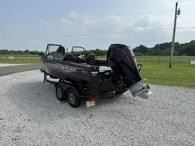 Slide: The Image of 2023 Tracker V-19 WT TARGA boat on trailer, parked on gravel, with outboard motor. - 6