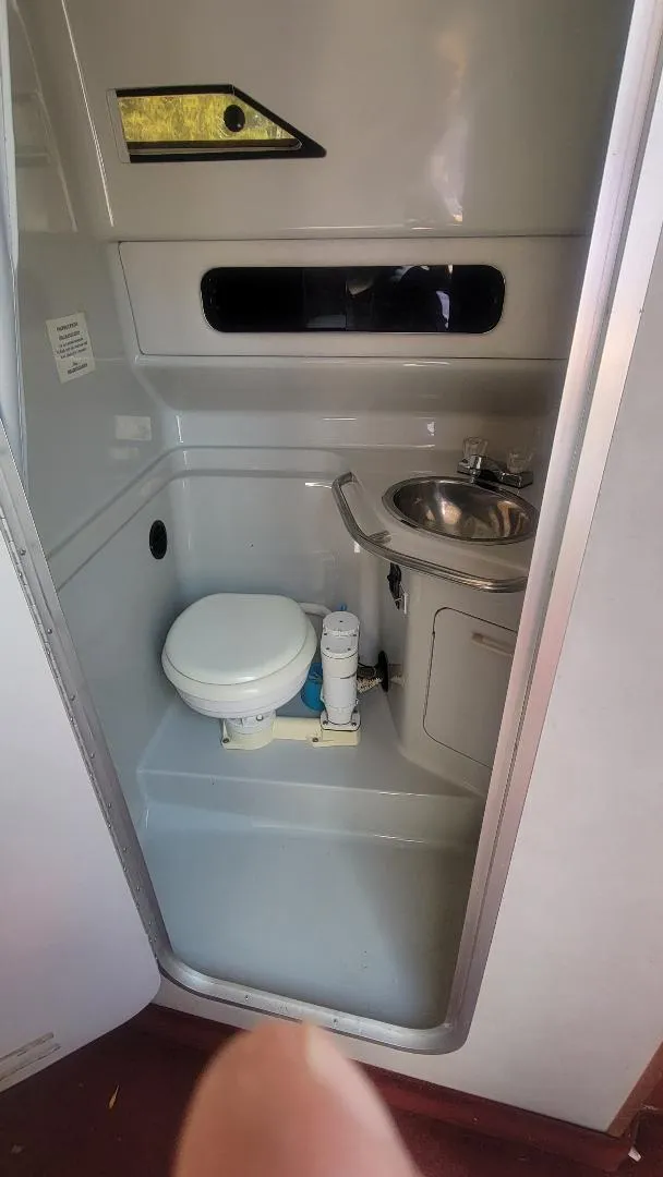 Slide: The Image of 1990 Sea Ray 270 Sundancer boat bathroom with toilet and sink. - 5