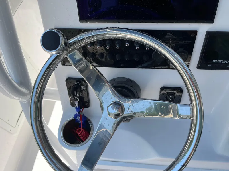 Slide: The Image of Steering wheel of 2022 Aquasport 2300 Center Console boat with control panel. - 10