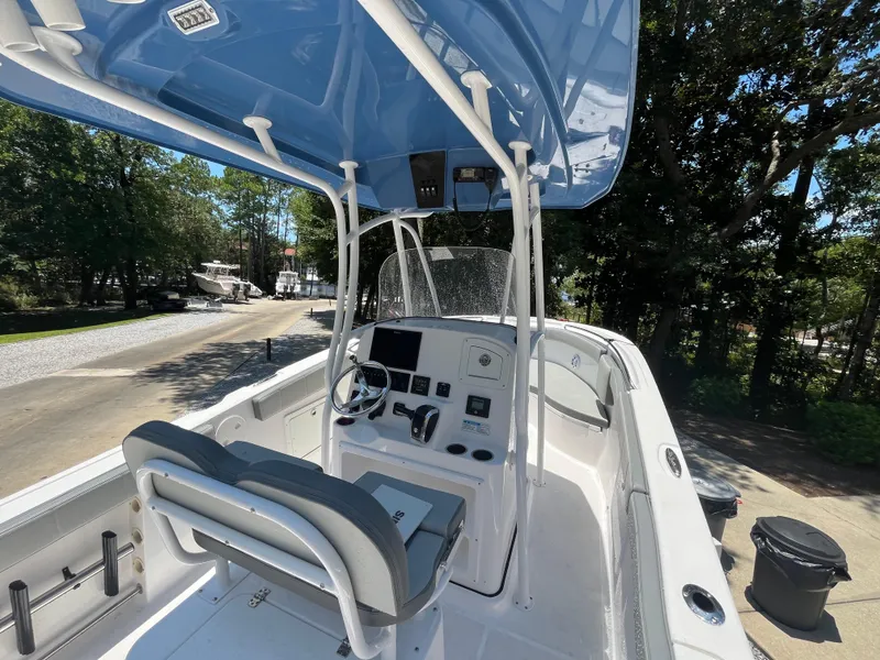 Slide: The Image of 2022 Aquasport 2300 Center Console boat with blue canopy and modern dashboard. - 19