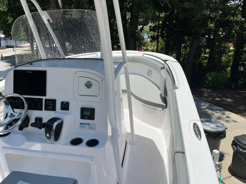 Slide: The Image of 2022 Aquasport 2300 Center Console boat with modern dashboard and steering wheel. - 20