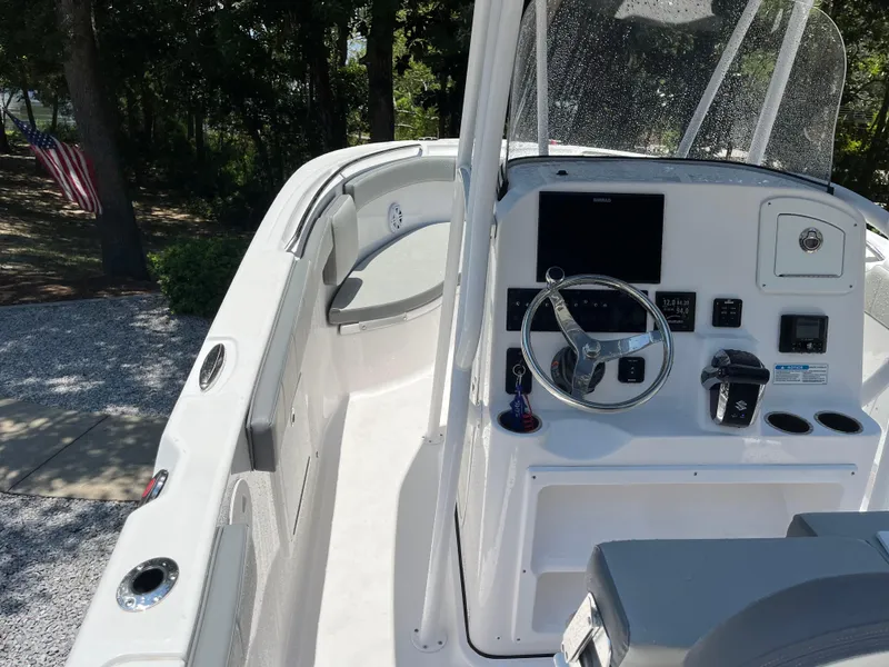 Slide: The Image of 2022 Aquasport 2300 Center Console boat interior with steering wheel and controls. - 21