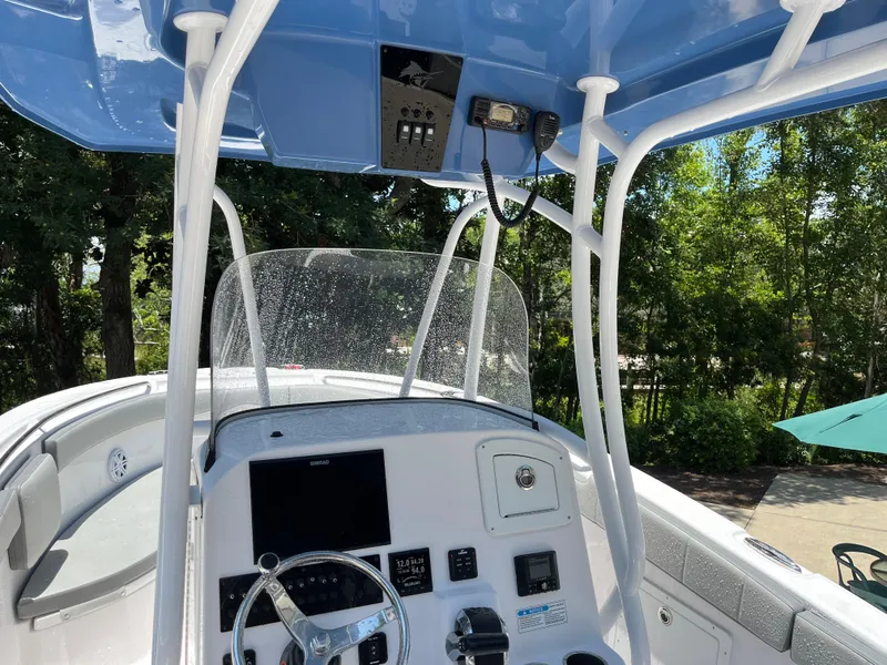 Slide: The Image of 2022 Aquasport 2300 Center Console boat interior with steering wheel and control panel. - 22