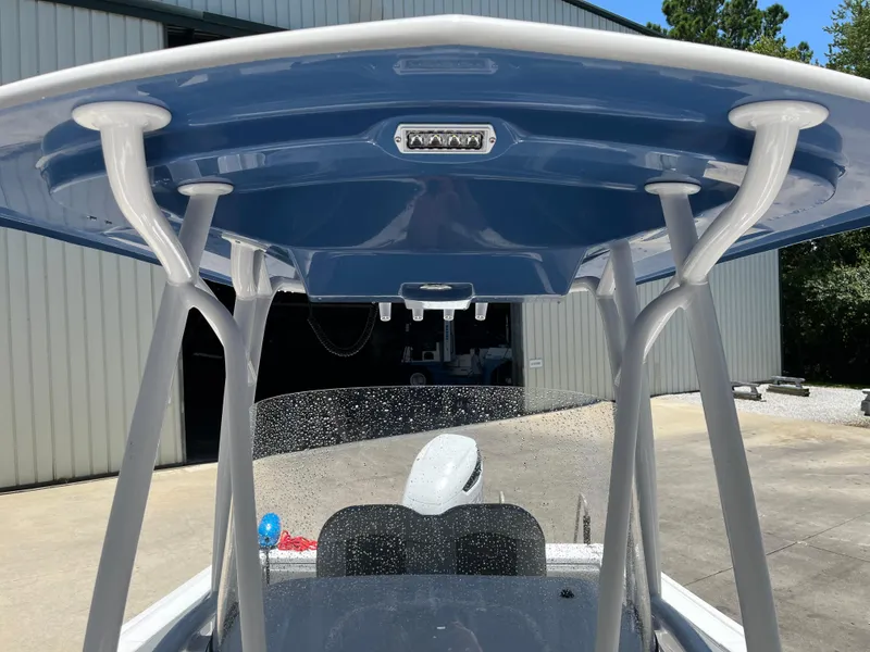 Slide: The Image of 2022 Aquasport 2300 Center Console boat with blue T-top and sturdy support poles. - 28