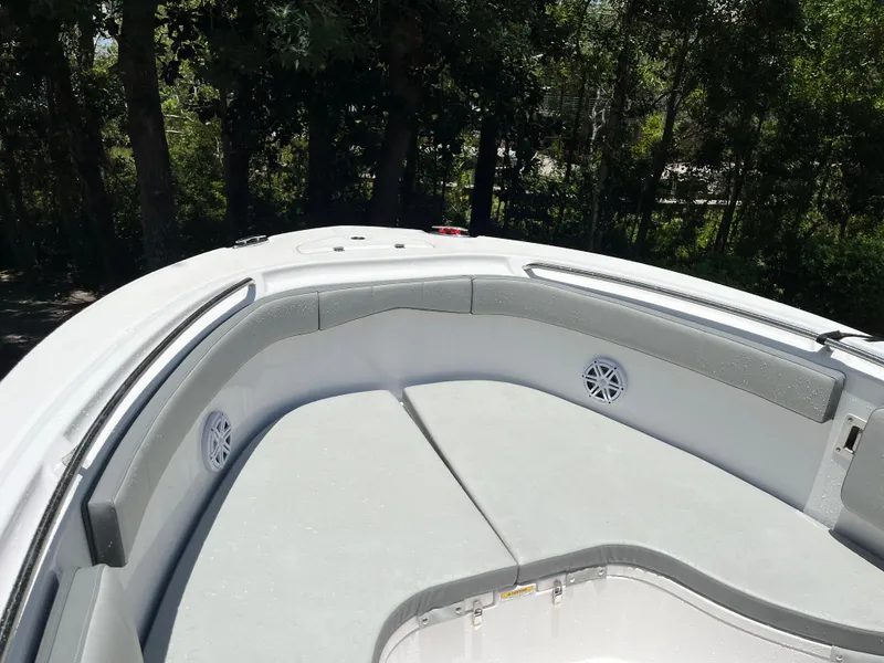 Slide: The Image of 2022 Aquasport 2300 Center Console boat interior with cushioned seating and speakers. - 29