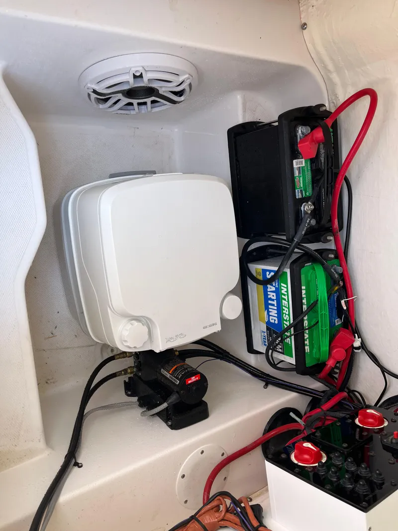 Slide: The Image of 2022 Aquasport 2300 Center Console battery compartment with wiring and components. - 32