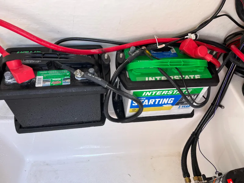 Slide: The Image of Batteries in a 2022 Aquasport 2300 Center Console boat with red and black cables. - 37