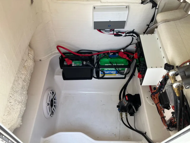 Slide: The Image of 2022 Aquasport 2300 Center Console boat battery compartment with wiring and speaker. - 39