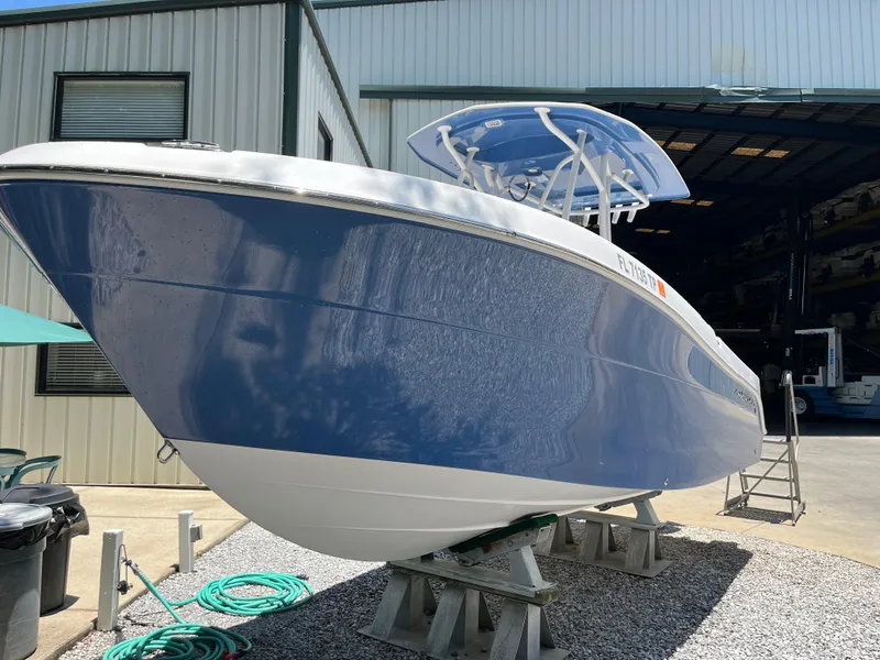 Slide: The Image of 2022 Aquasport 2300 Center Console boat on stands outside a warehouse. - 4