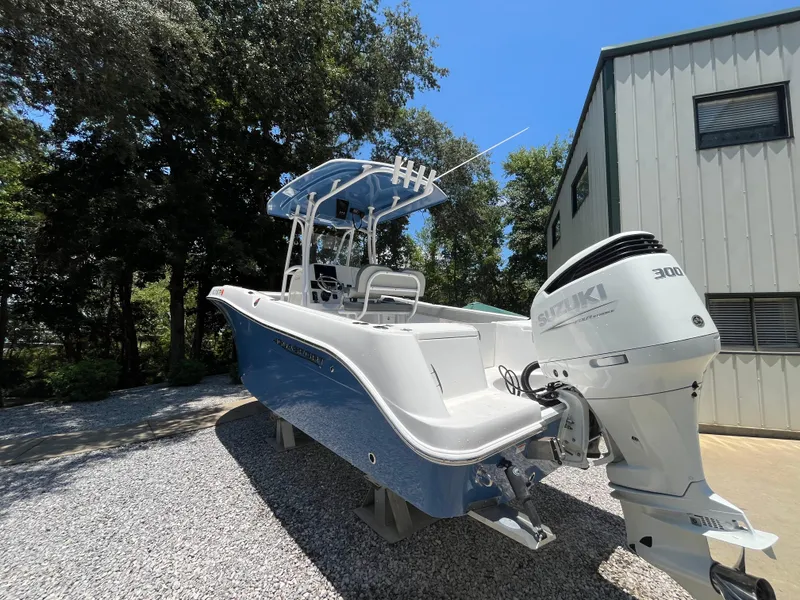 Slide: The Image of 2022 Aquasport 2300 Center Console boat with Suzuki engine, parked outdoors. - 5