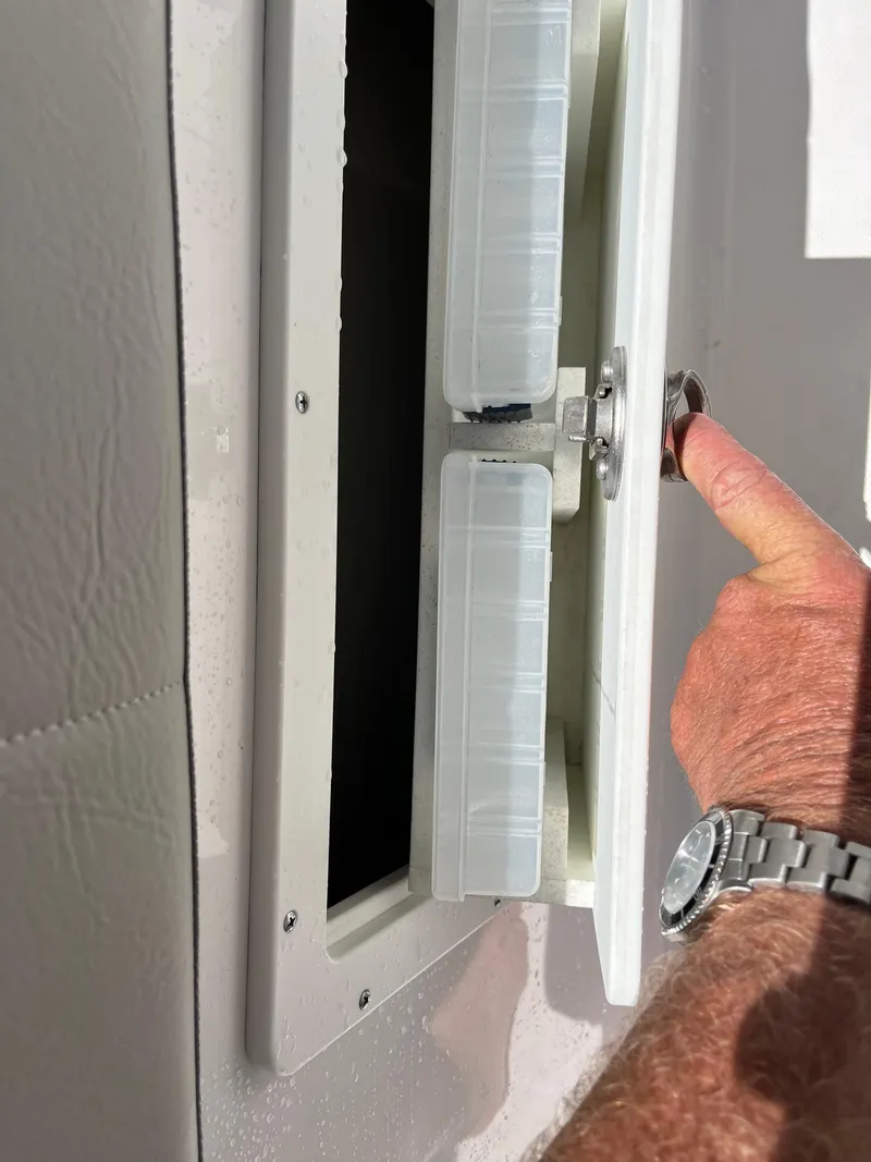 Slide: The Image of 2022 Aquasport 2300 Center Console storage compartment being opened. - 7