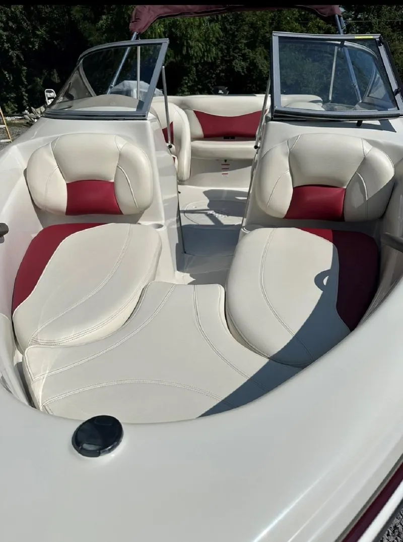 Slide: The Image of 2014 Tahoe Q4i boat interior with white and red seating, open windshield, and lush greenery background. - 3